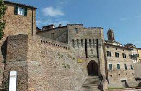 Castello medievale in pietra con scalinata e torre, tipico dell'architettura italiana.